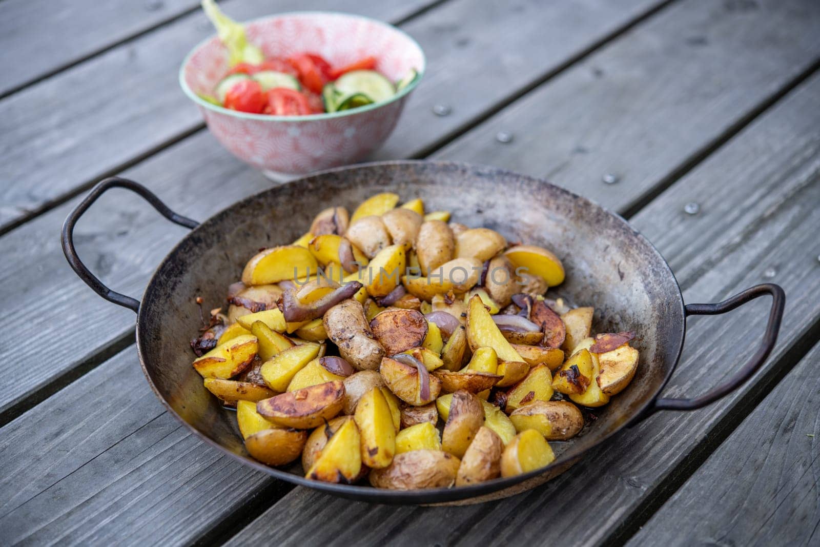 grilled potatos with onionin and salad iron pan