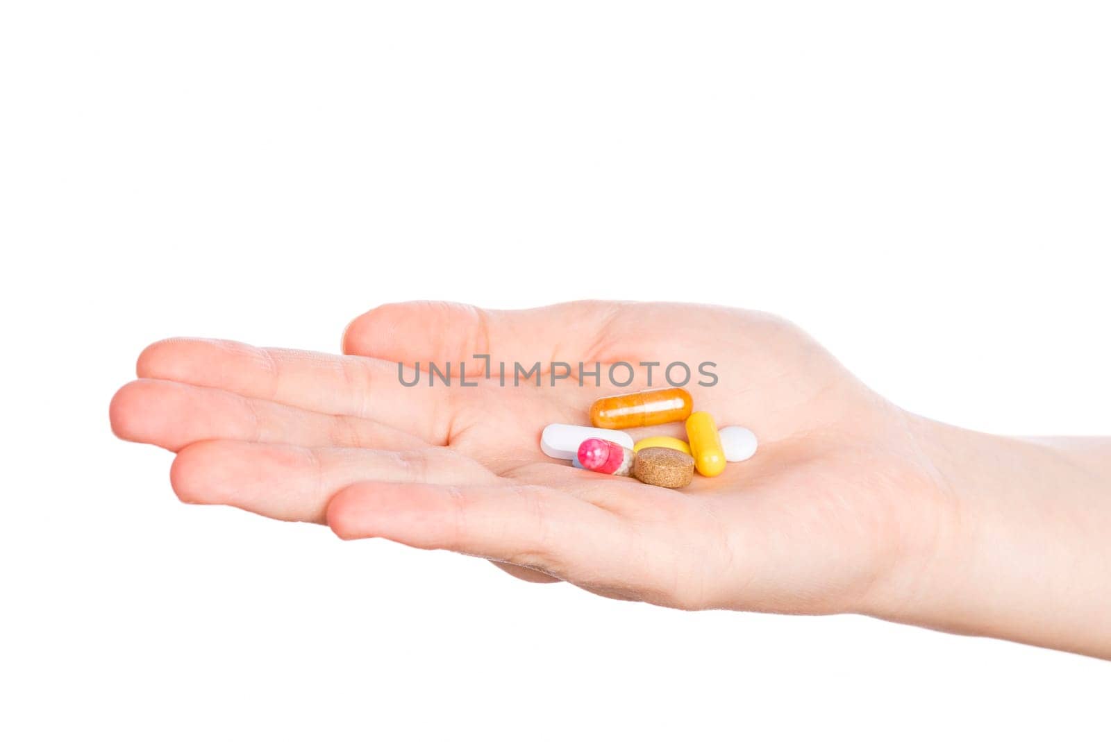 Pills in woman hand isolated on white background. Woman hand holding pills on white