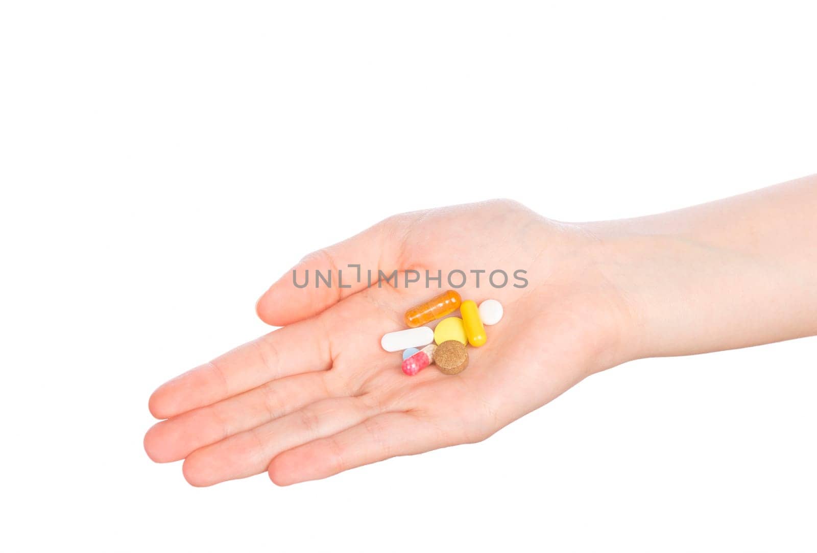 Pills in woman hand isolated on white background. Woman hand holding pills on white