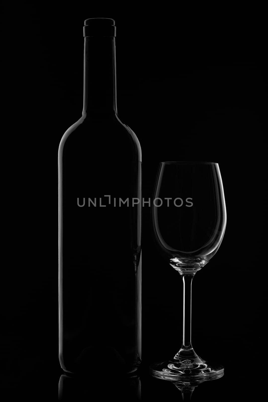 Silhouette of wine bottle and empty wineglass on a black background with reflection. Contour with gradient and highlights