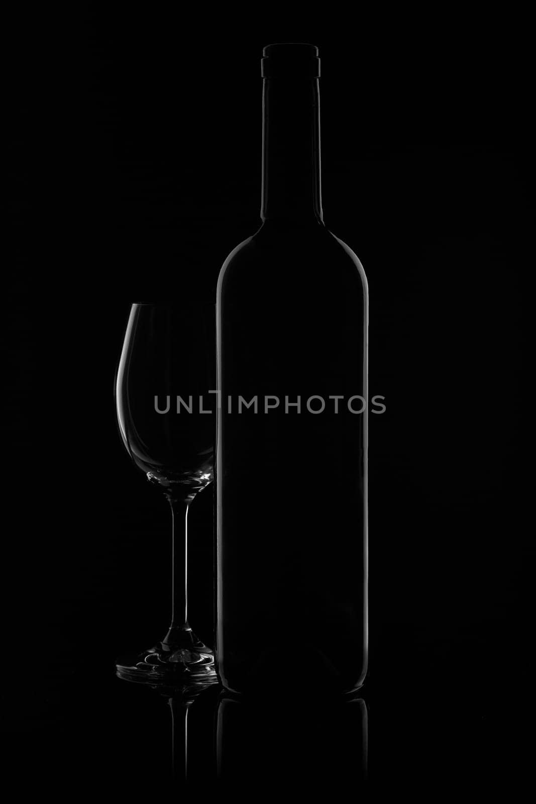 Silhouette of wine bottle and empty wineglass on a black background with reflection. Contour with gradient and highlights
