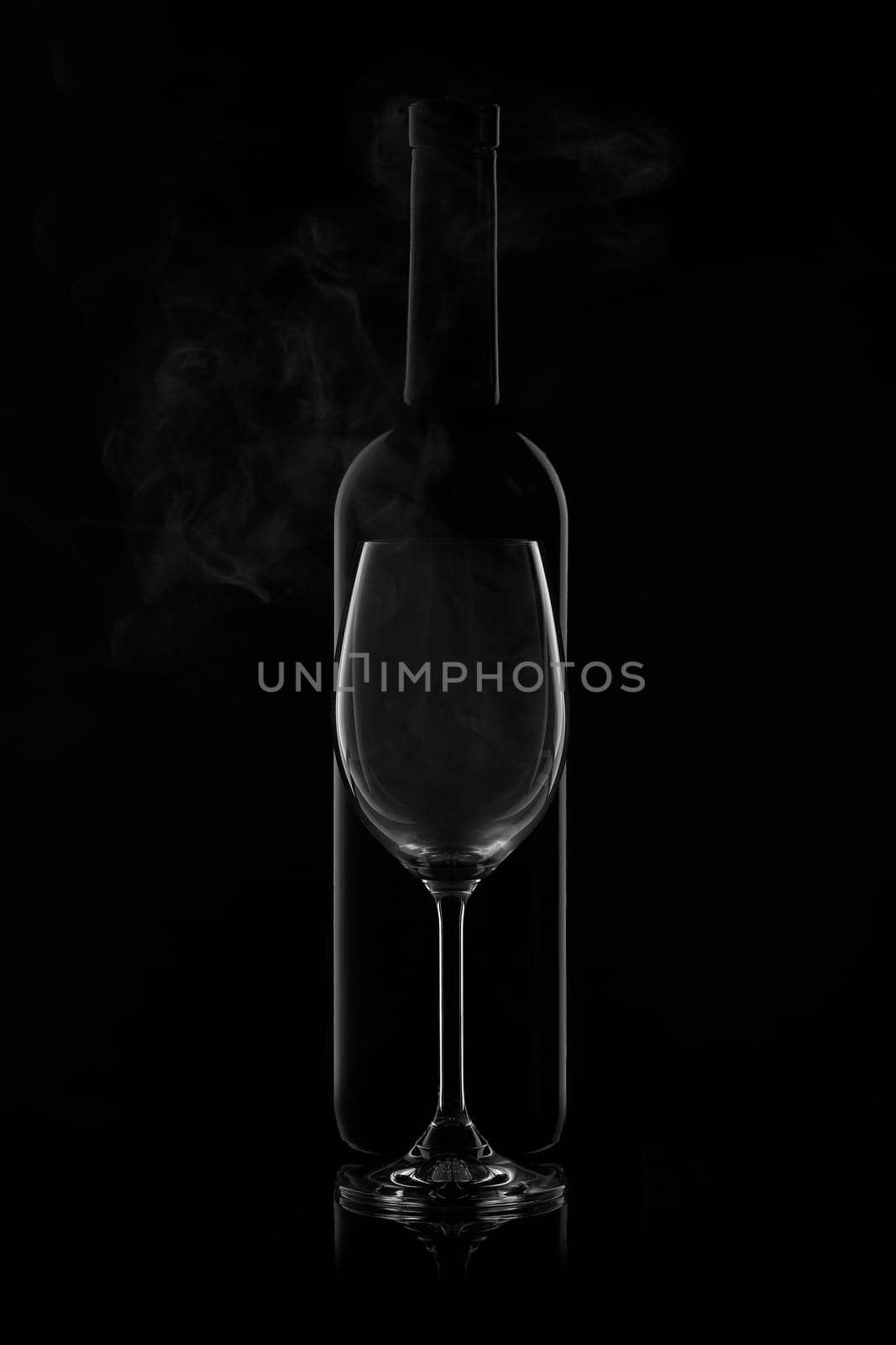 Silhouette of wine bottle and empty wineglass on a black background with reflection. Contour with gradient and highlights