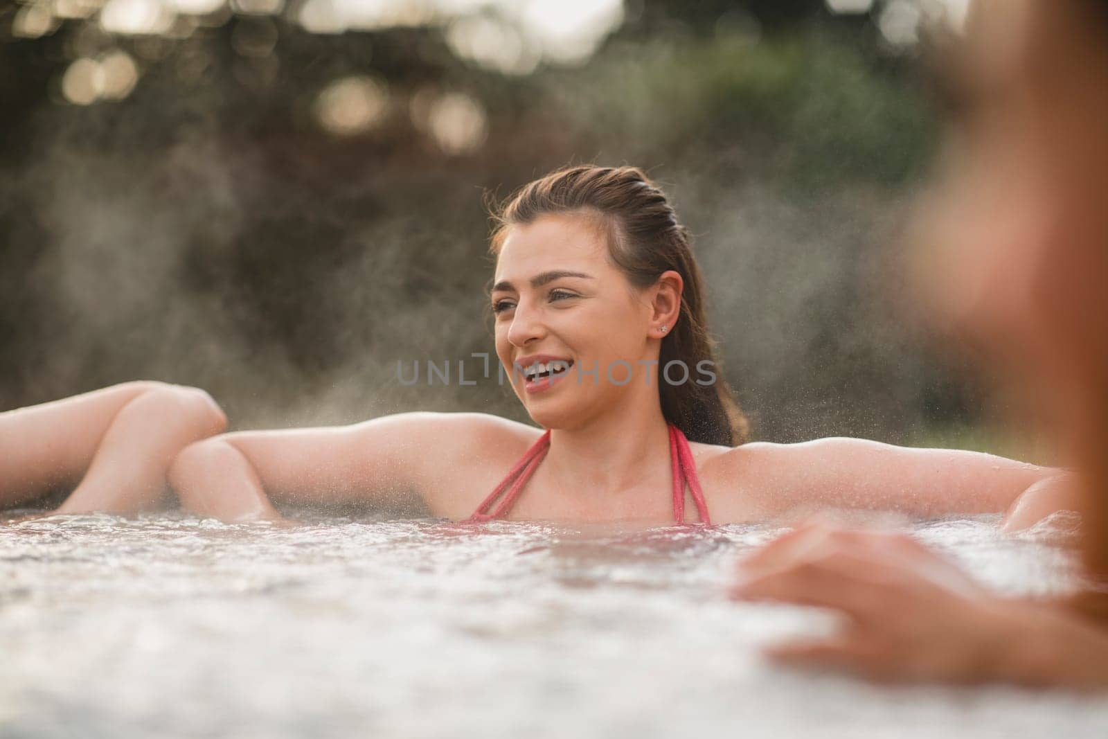 Mid adult woman relaxing in a hot tub with her friends.