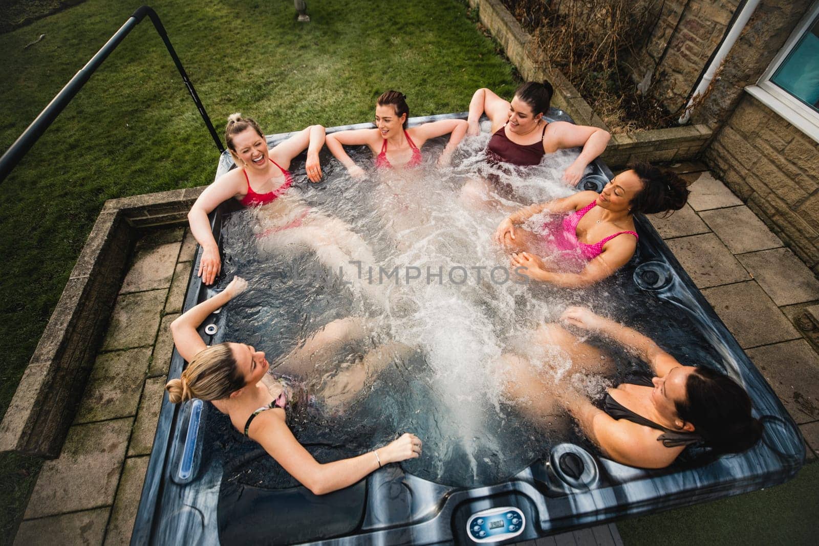 High angle view of a small group of female friends relaxing in a hot tub together.