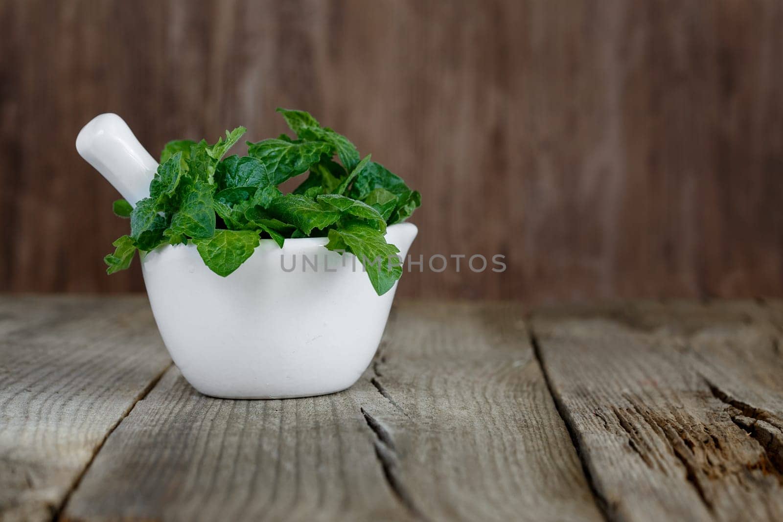 A bunch of green fresh curly mint on a wooden background
