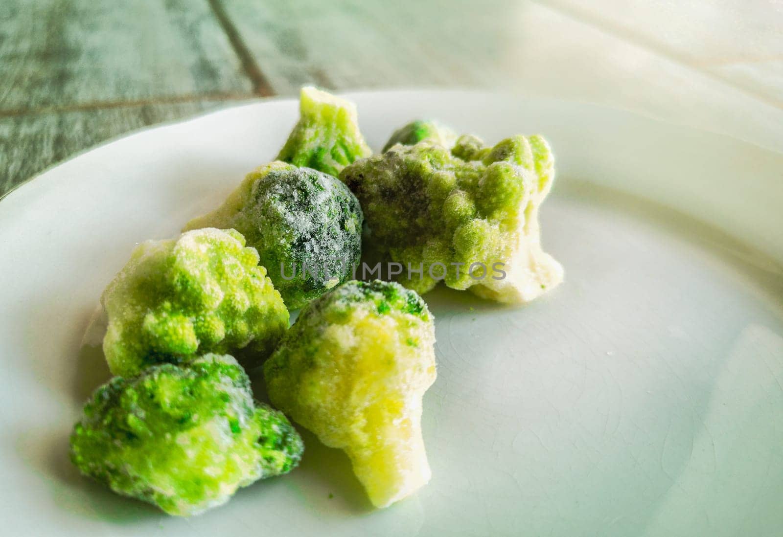 frozen veggies frosted broccoli icing outside freezer fridge .