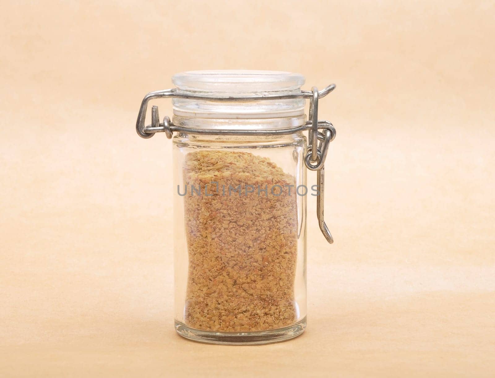 Wheat germs in closed jar on brown background