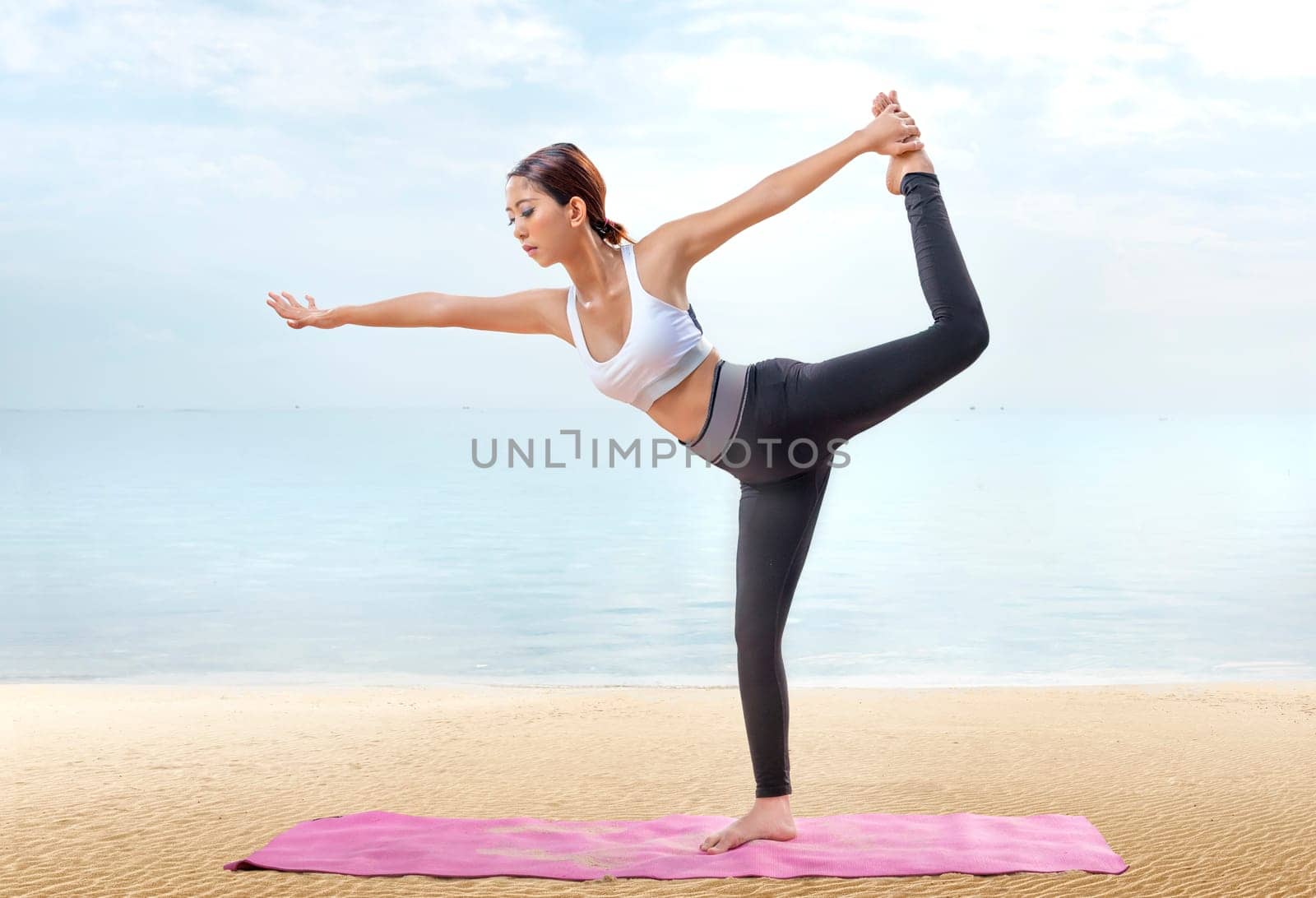 Asian healthy woman practicing yoga on the carpet in beach. Healthy concept