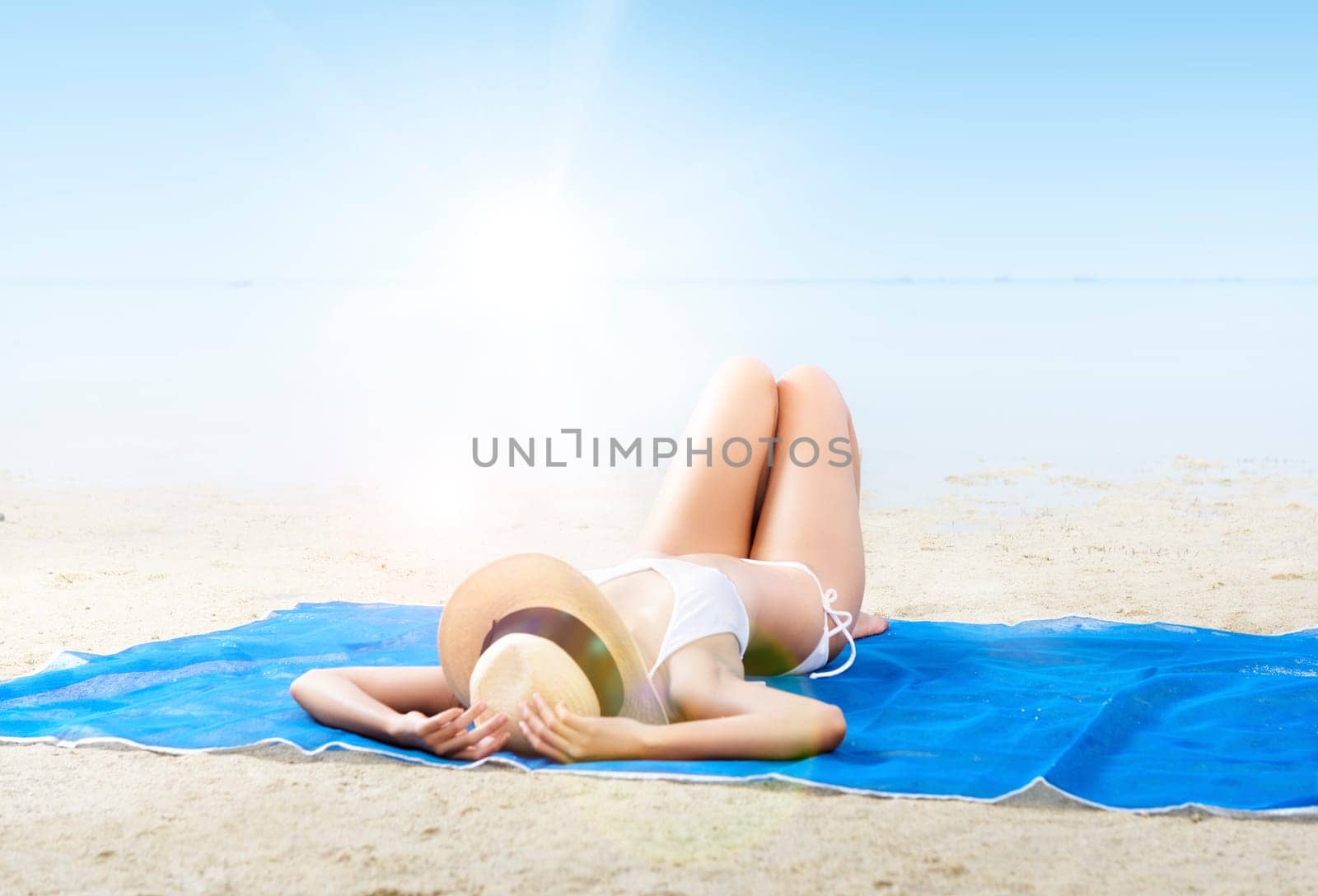 Asian sexy girl in bikini and hat lying on the carpet in beach. Summer vacation