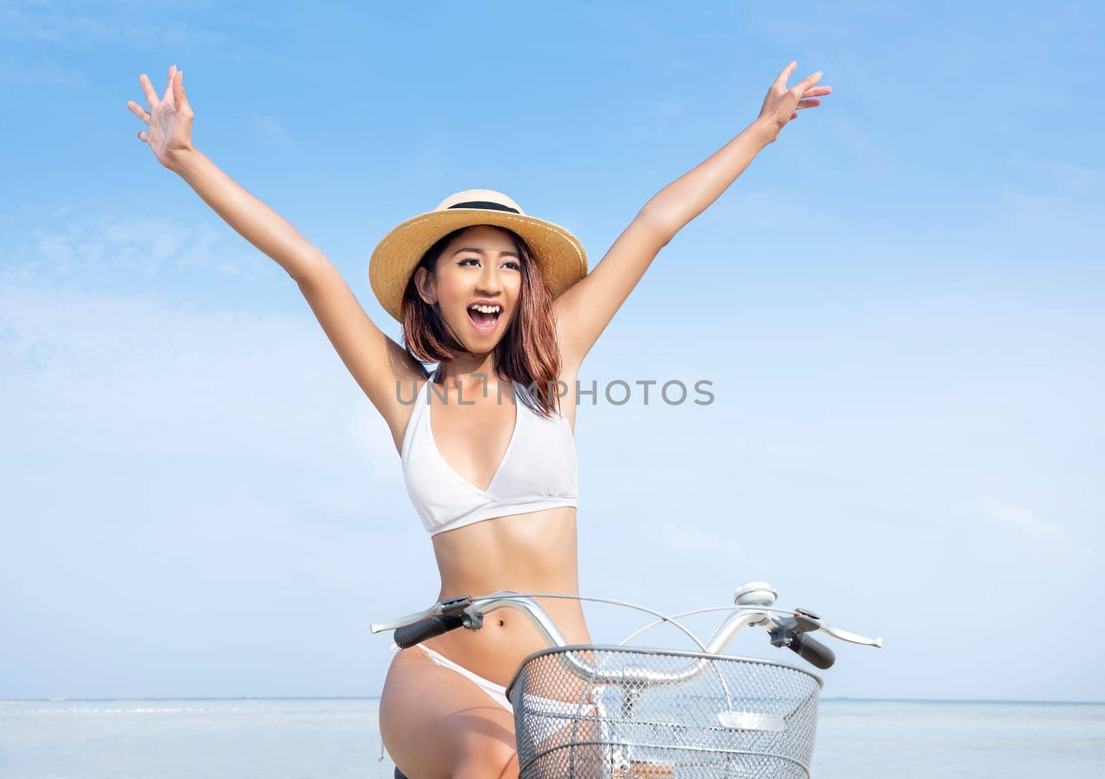 Close up view of asian sexy girl with hat and bikini riding bicycle on the beach. Summer vacation