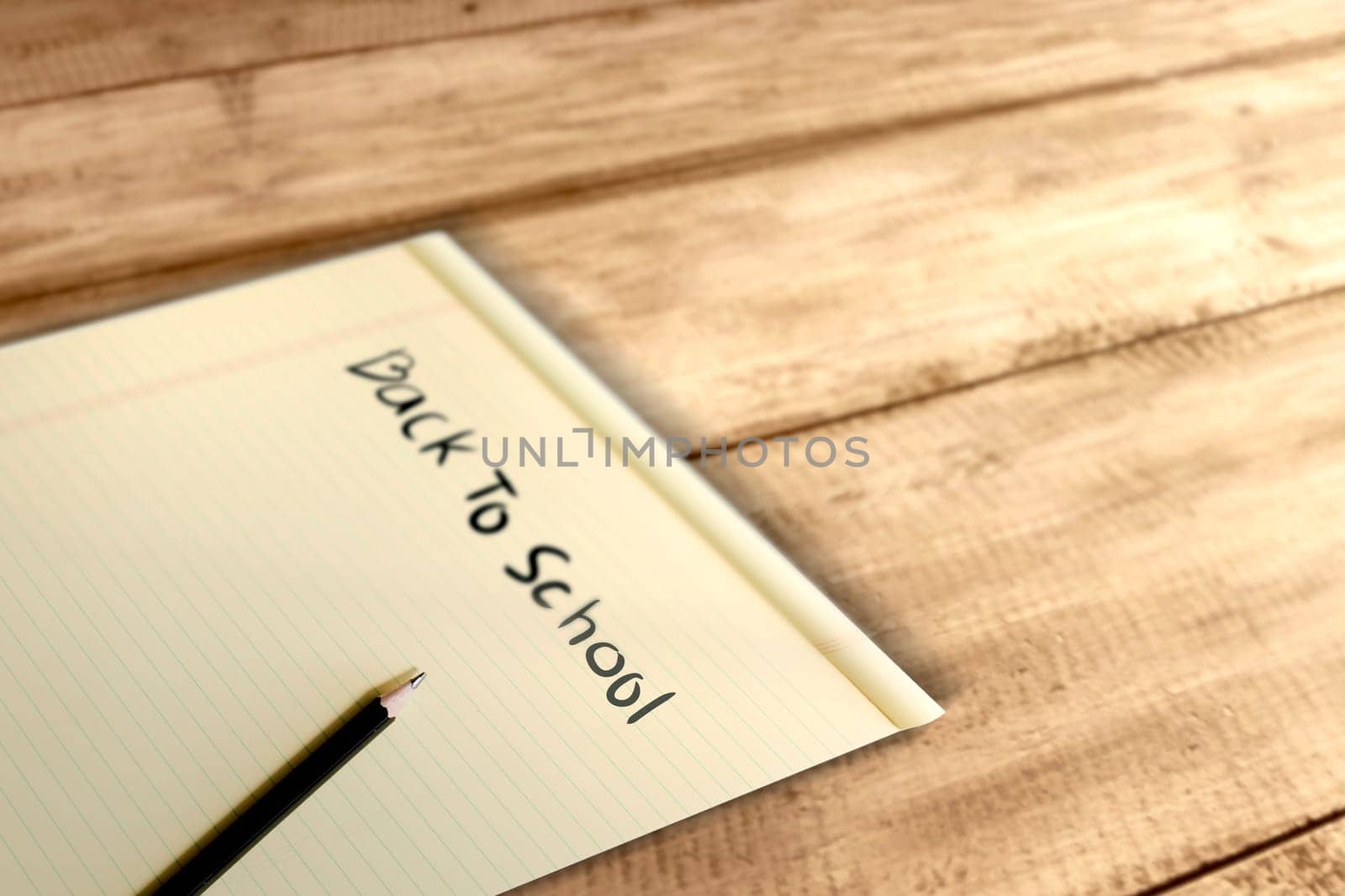 Paper and pencil with Back to School message on wooden table. Back to School concept