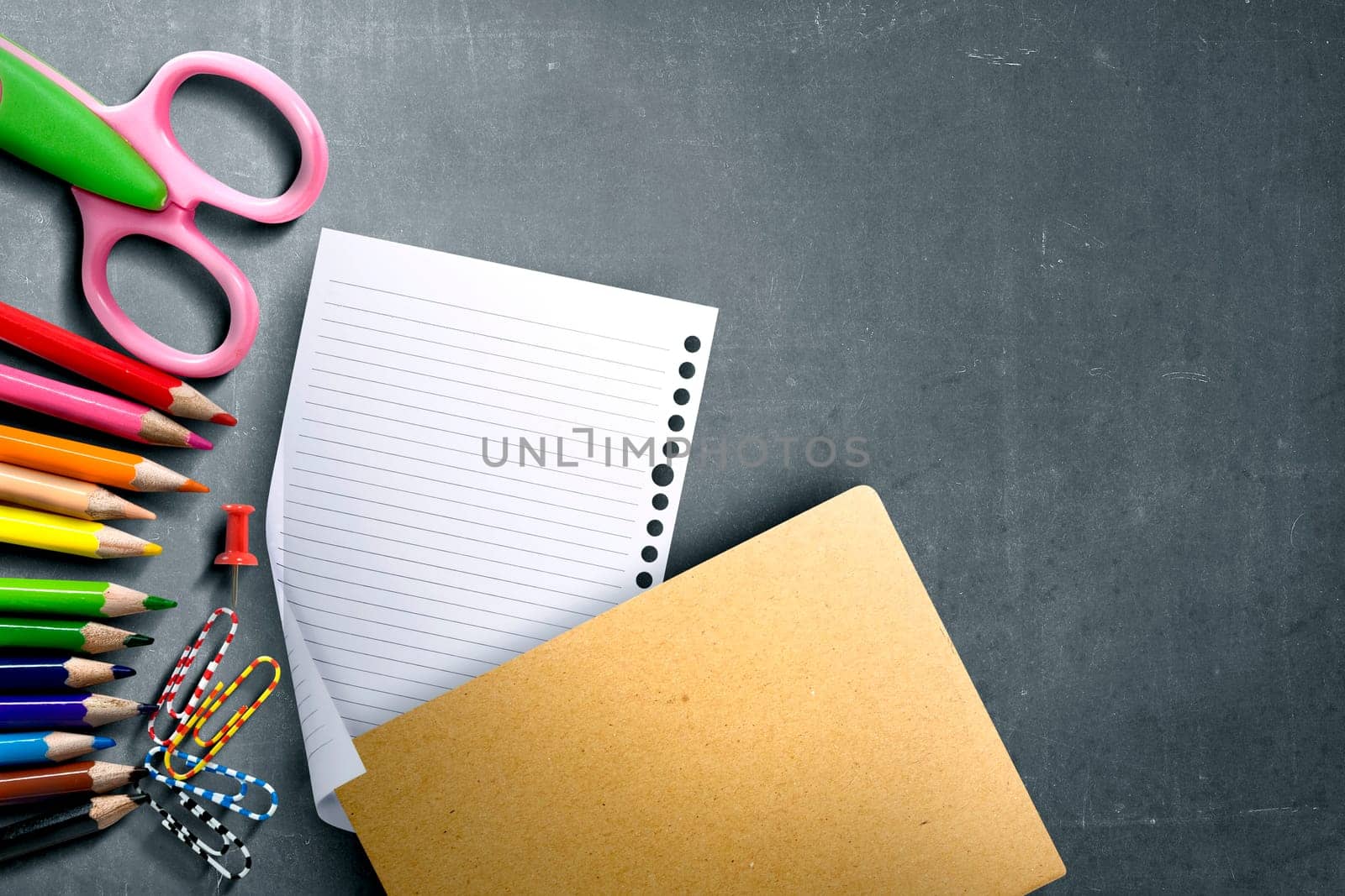 School supplies and stationery with white paper on blackboard with copyspace. Back to School concept