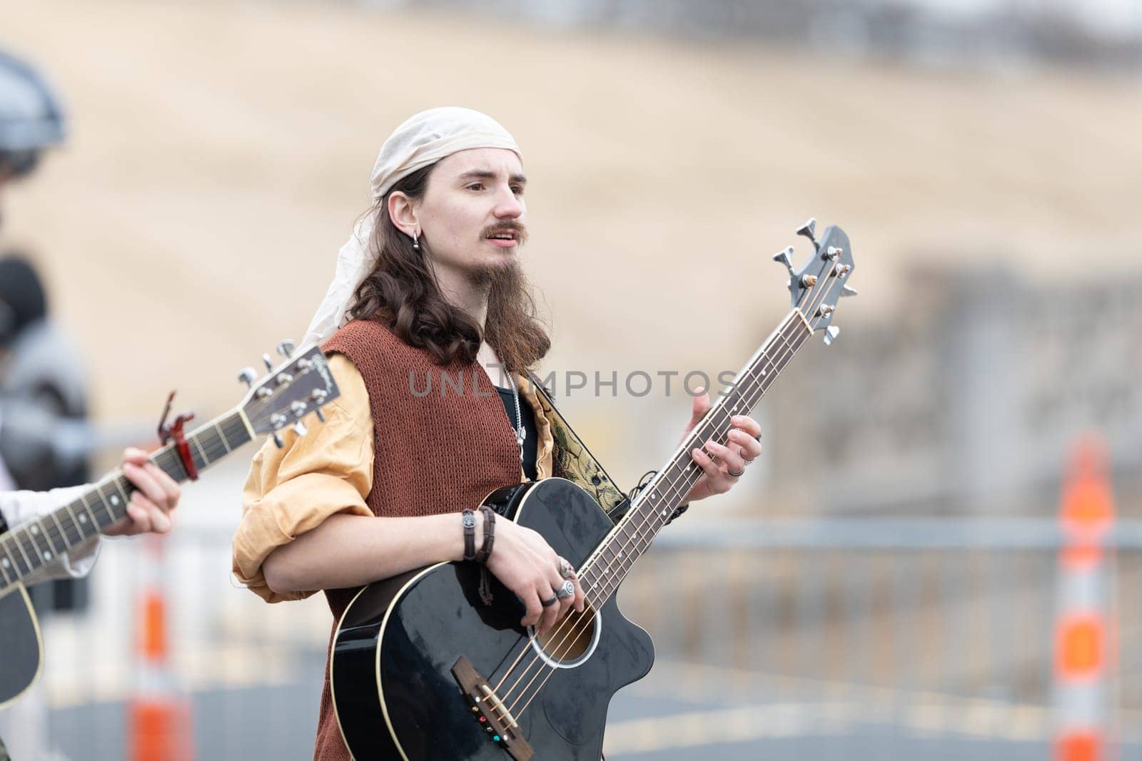 St. Louis, Missouri, USA - March 2, 2019: Bud Light Grand Parade, Man wearing a retro outfit playing the guitar, walking down 7th street
