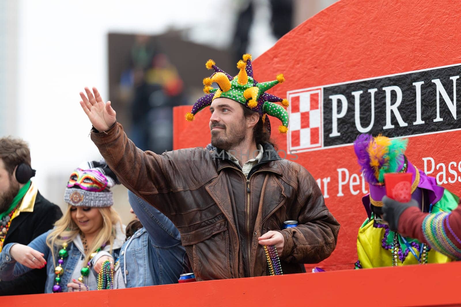 St. Louis, Missouri, USA - March 2, 2019: Bud Light Grand Parade, Man wearing a joker hat, on a float throwing beads to spectators