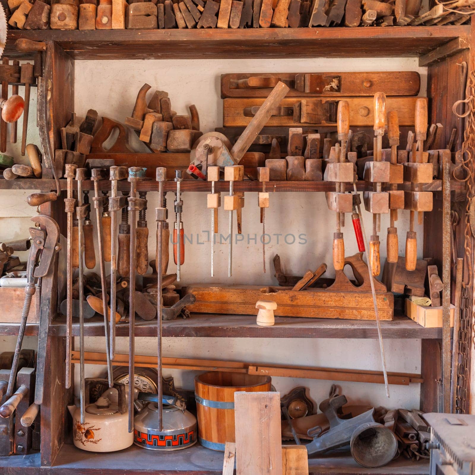 Shelf in a carpentry workshop with tools such as clamps, pliers, Hogel and other craft utensils.