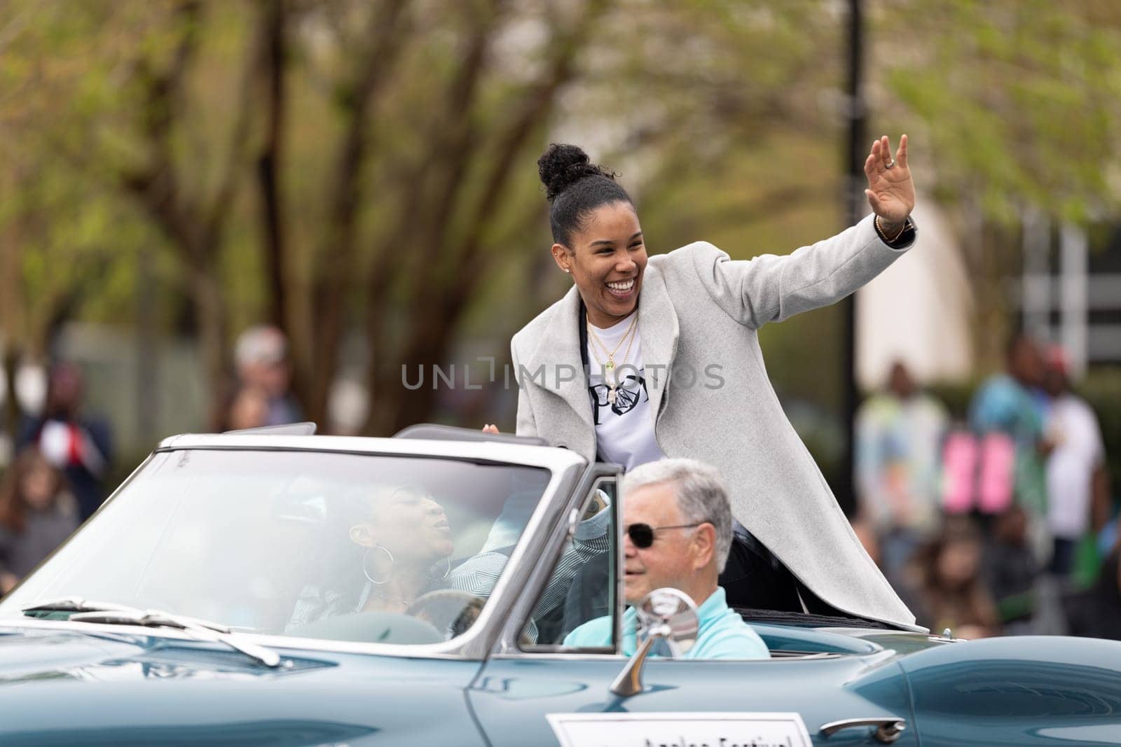 Wilmington, North Carolina, USA - April 6, 2019: The North Carolina.Azalea Festival, Tamera Young WNBA player, riding on a car waving at people at the parade
