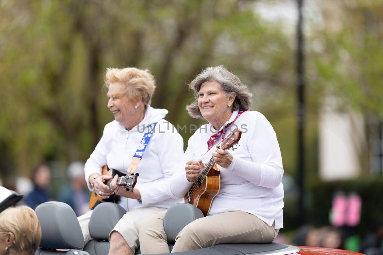 Wilmington, North Carolina, USA - April 6, 2019: The North Carolina.Azalea Festival, Members of the slightly off key stringalongs riding a car playing guitars at the parade