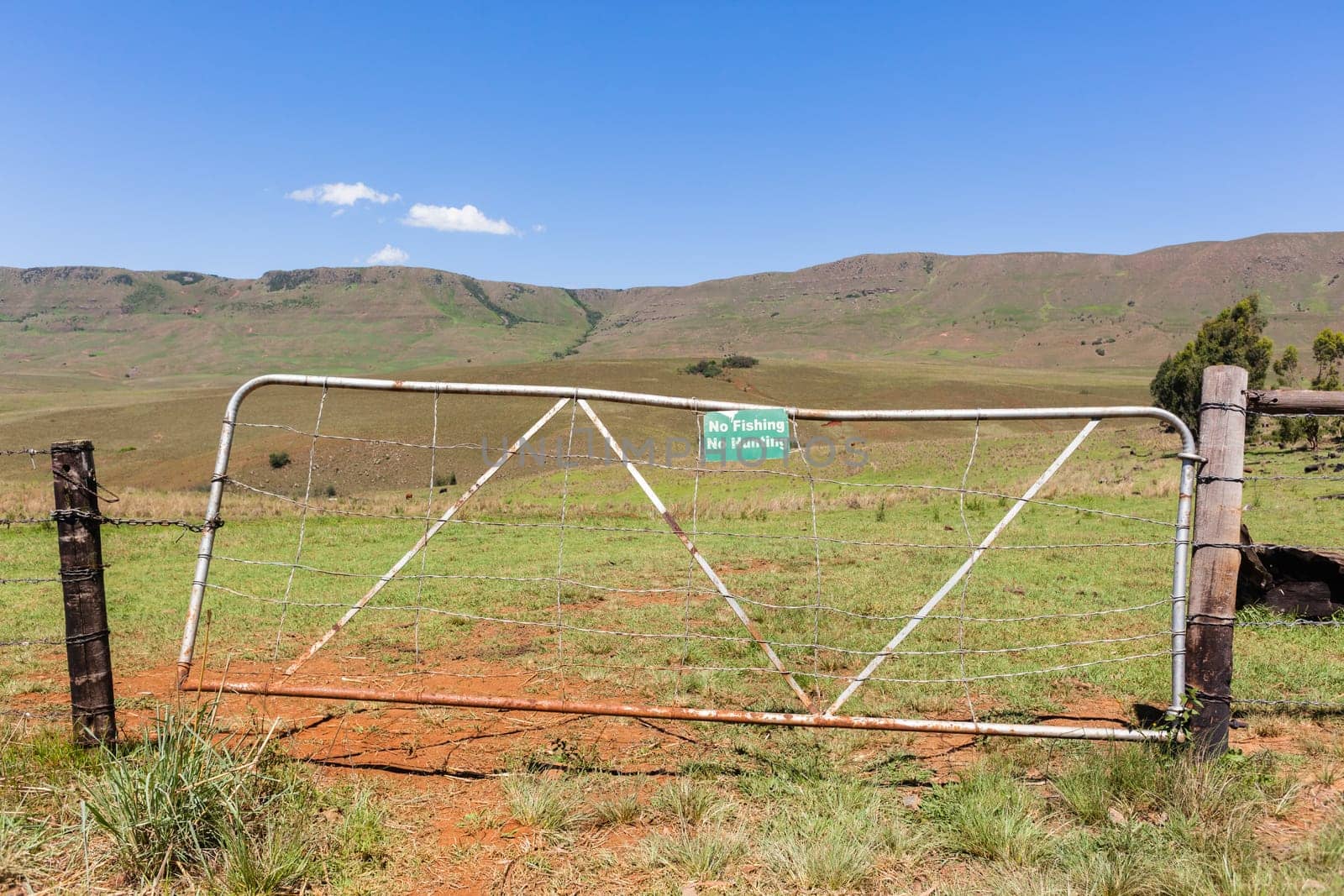 Mountains farm gate sign no-fishing no-hunting farmer property closeup photo.