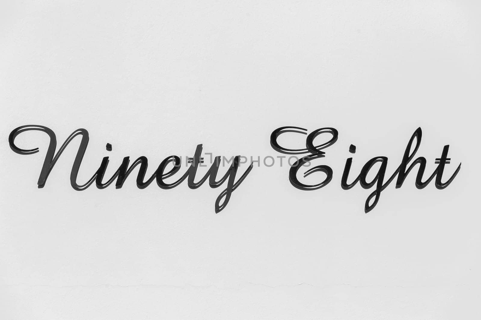 Number ninety eight address sign on wall outside.