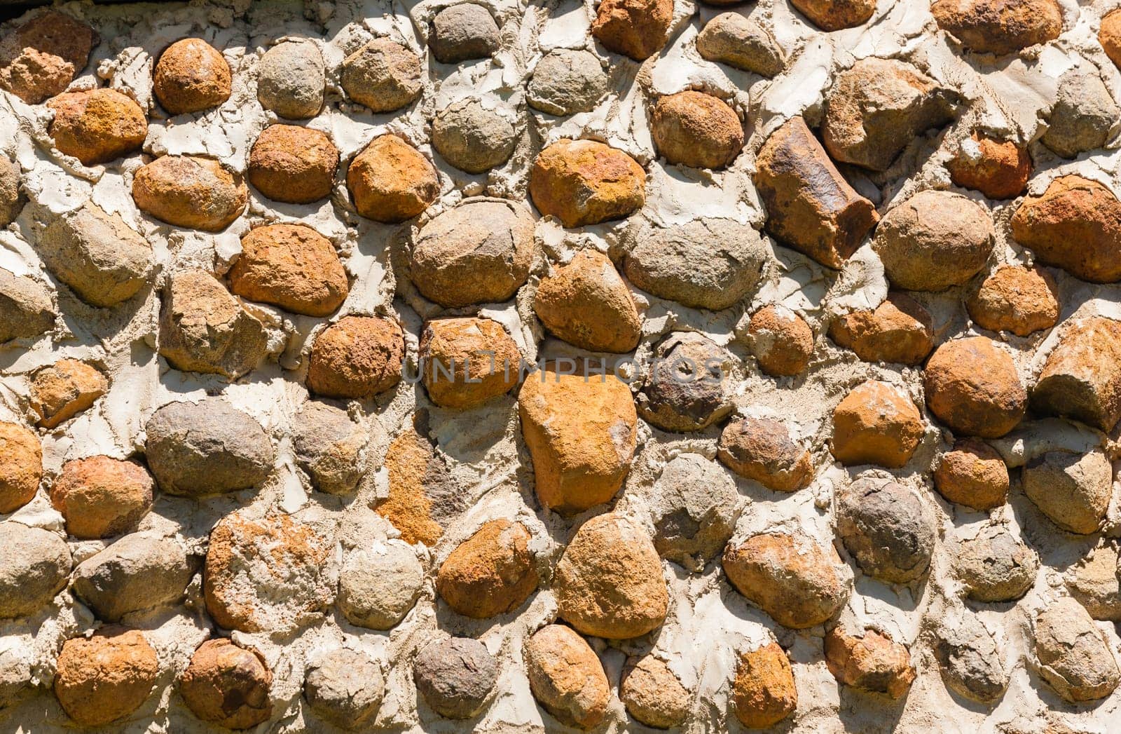Building outside walls built with river stones natural resources closeup detail textures background structure.
