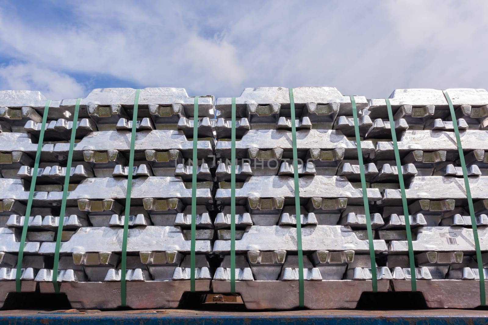 Aluminum ingots industrial materials stacked on truck transport trailer from refinery to factory processing manufacture products.