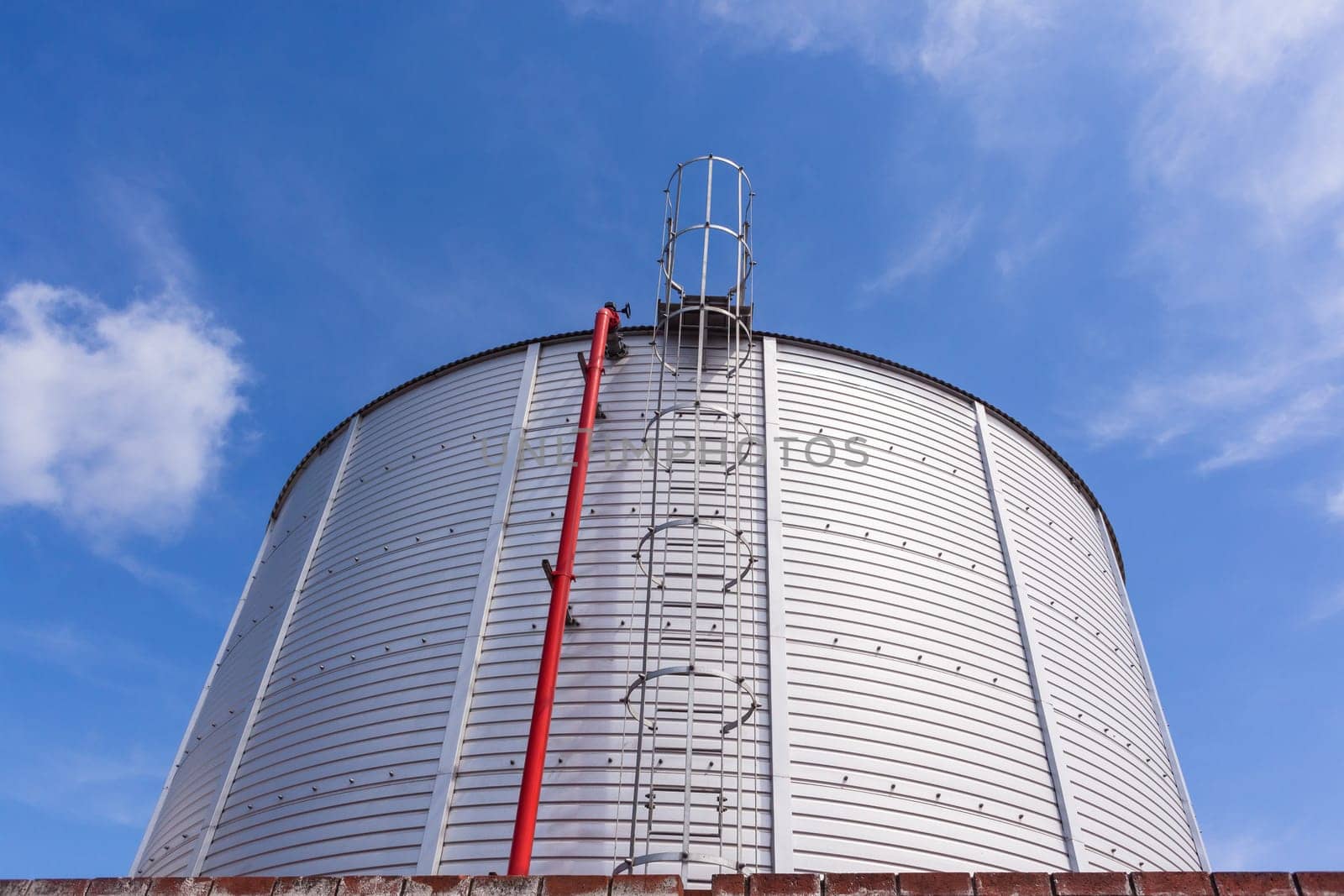 Steel storage liquid water chemical tank closeup blue sky.