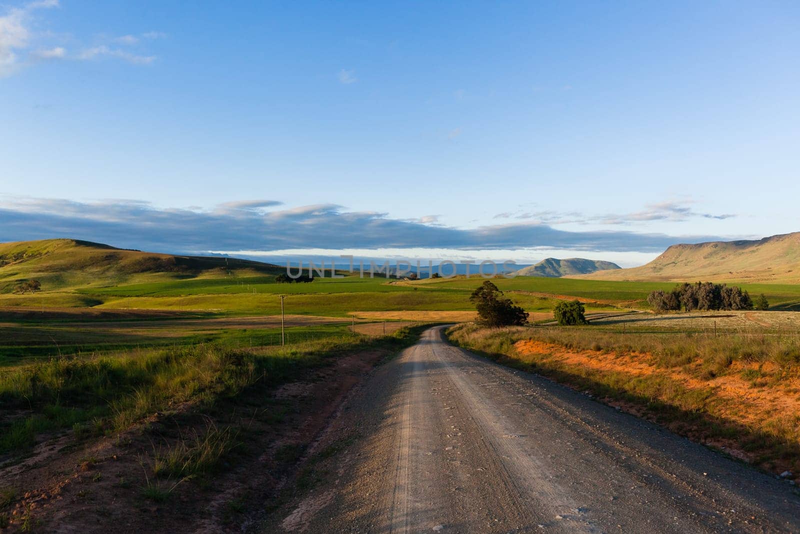 Dirt road route through scenic rural mountain farming terrain summer landscape.
