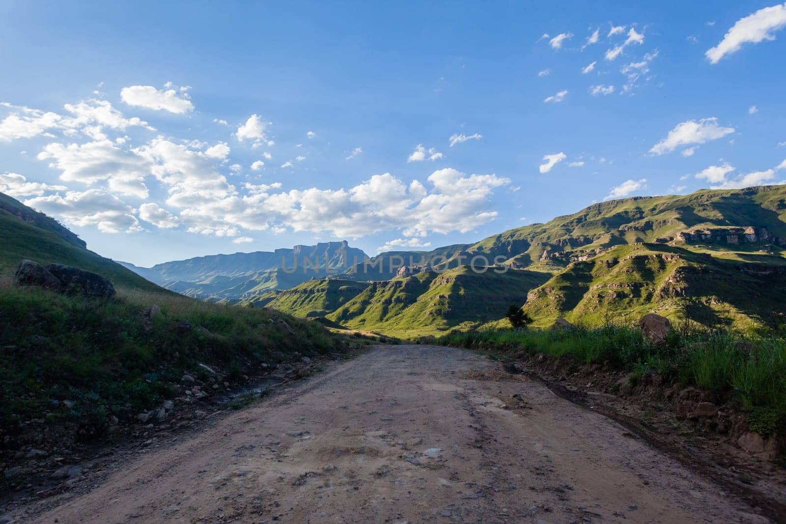 Mountains dirt road route through scenic rural mountain farming terrain summer landscape.