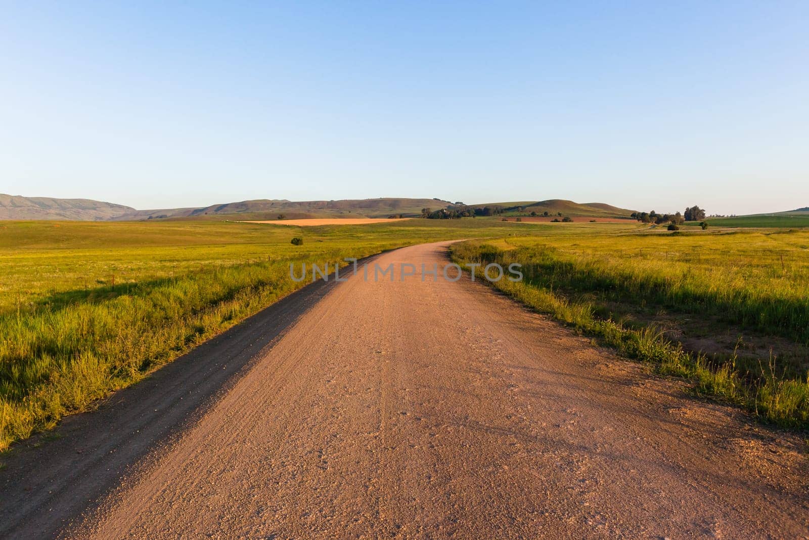 Mountains dirt road route through scenic rural mountain farming terrain summer landscape.
