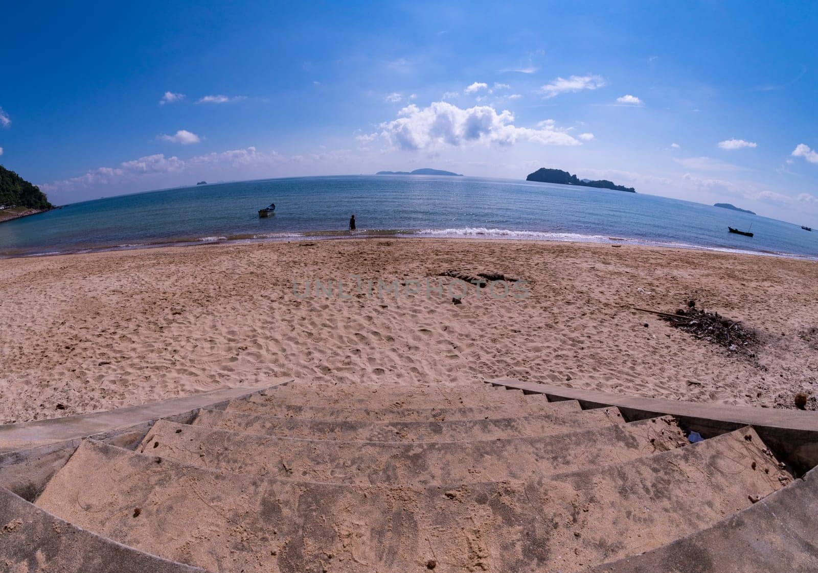 The stairs down to the beach. The beach with the sky and the blue sea.