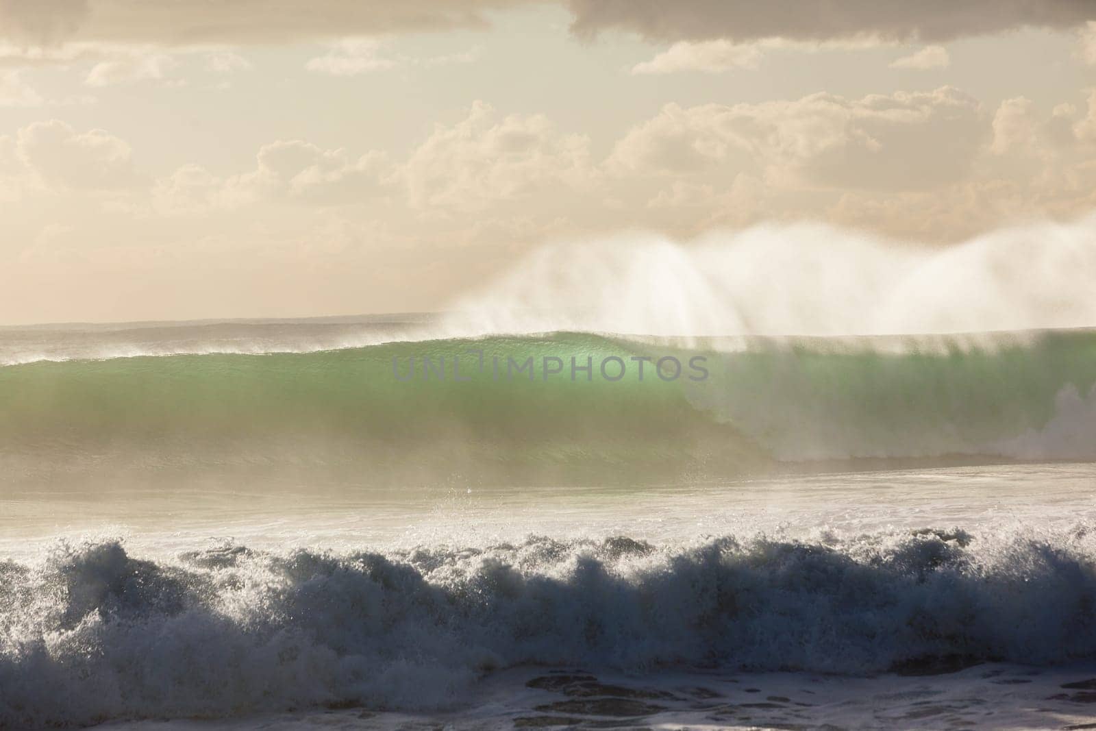 Ocean waves crashing water power towards beach from weather storms.