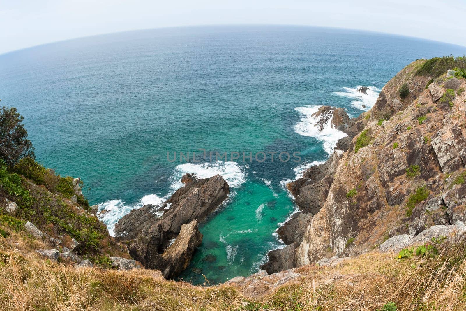 Ocean blue waters below high elevation overlooking rocky cliffs landscape