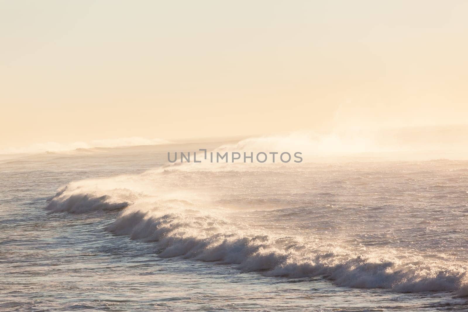 Ocean waves crashing white water spray morning rolling towards beach coastline