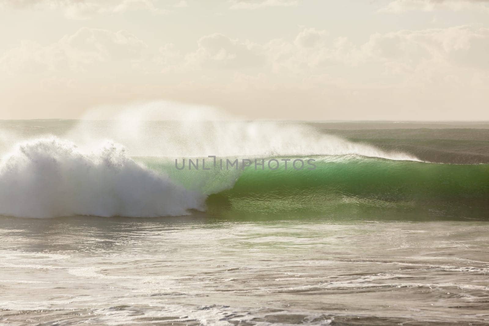 Ocean waves crashing water power towards beach from weather storms.