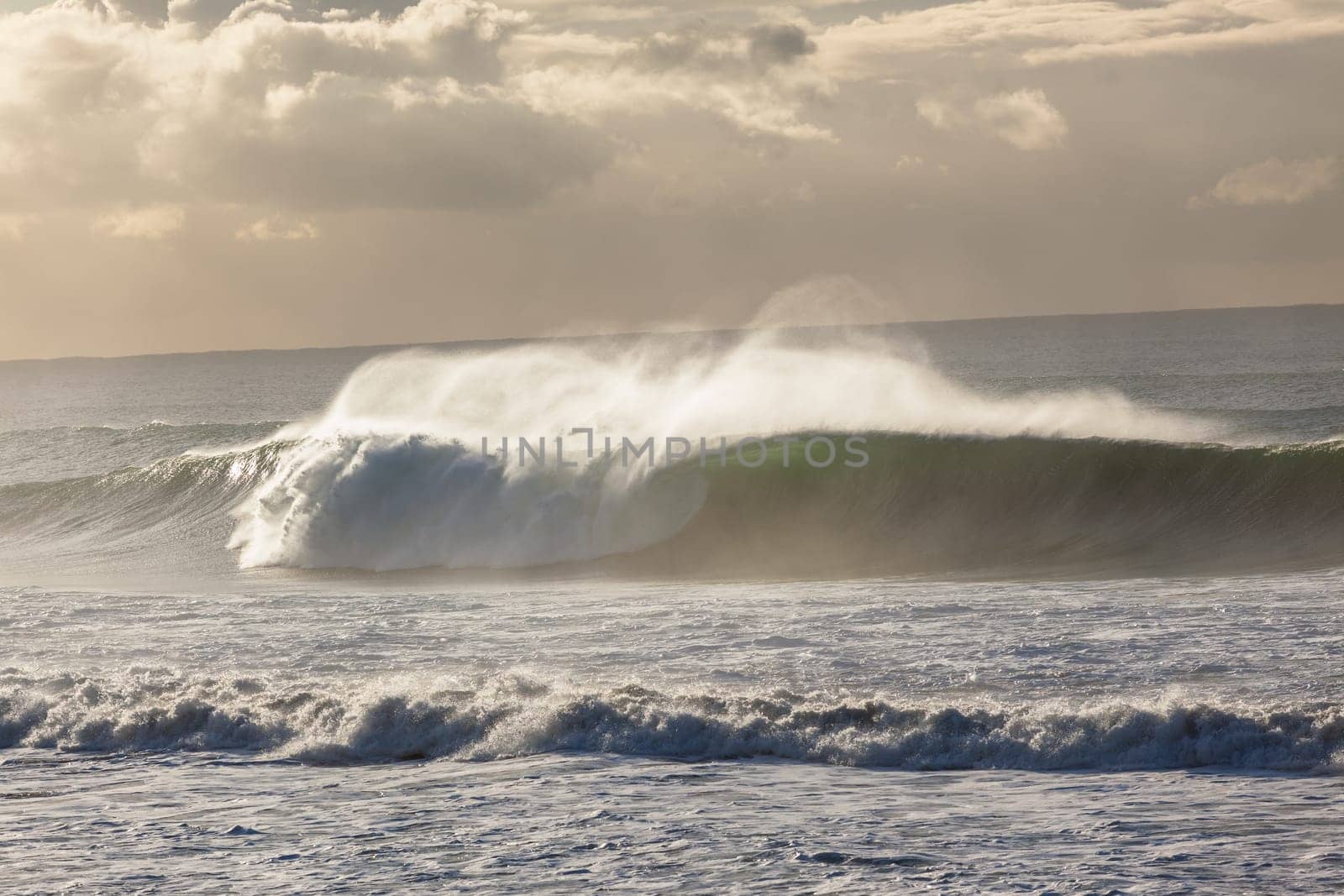 Ocean Waves crashing water power along beach rocky coastline from storm weather.