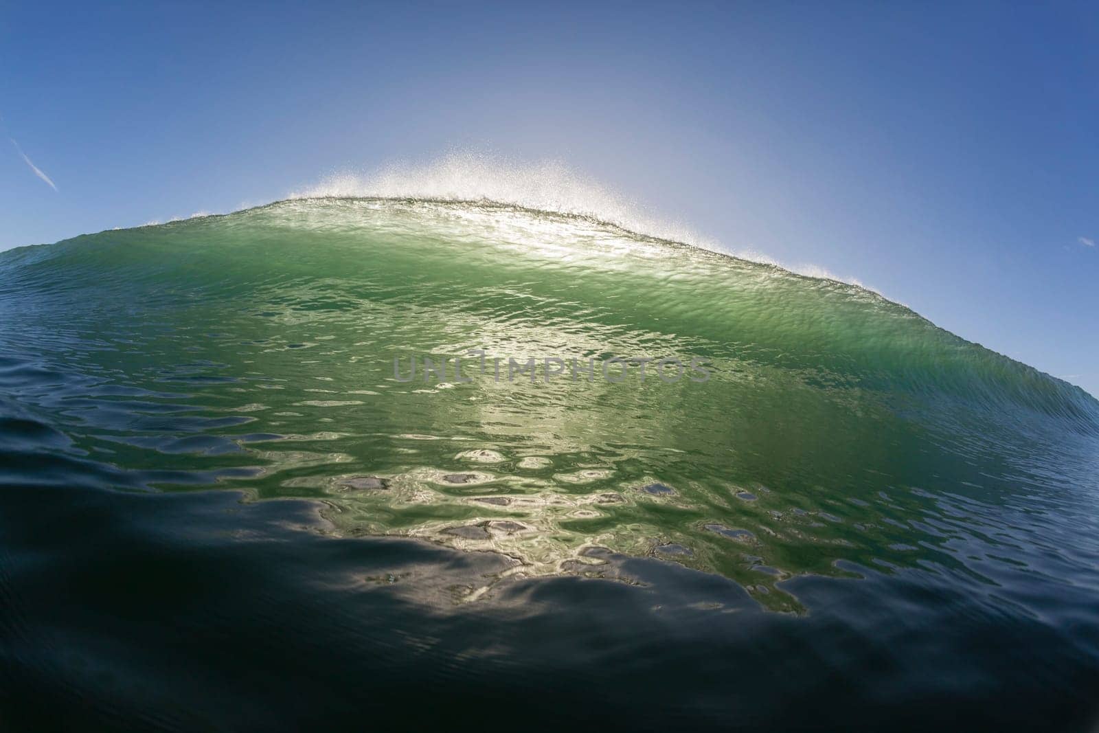 Wave ocean swimming encounter wall of water crashing breaking beauty nature power back-light closeup photo. .