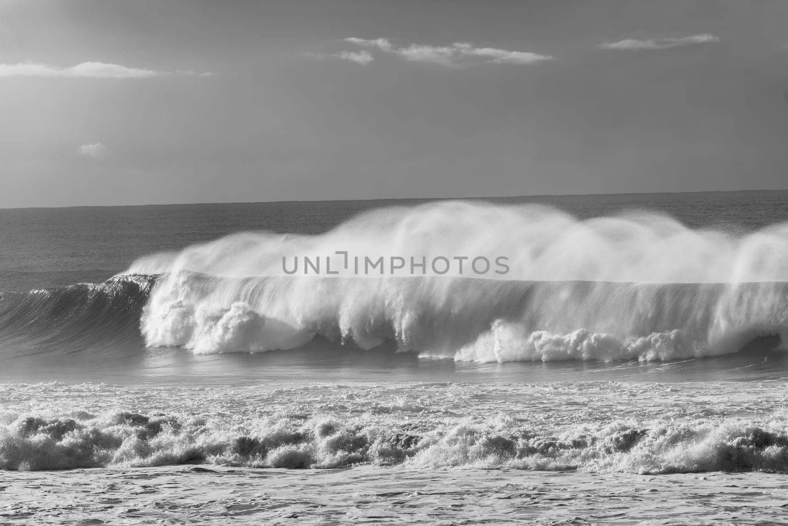 Ocean Waves crashing water power along beach rocky coastline from storm weather.