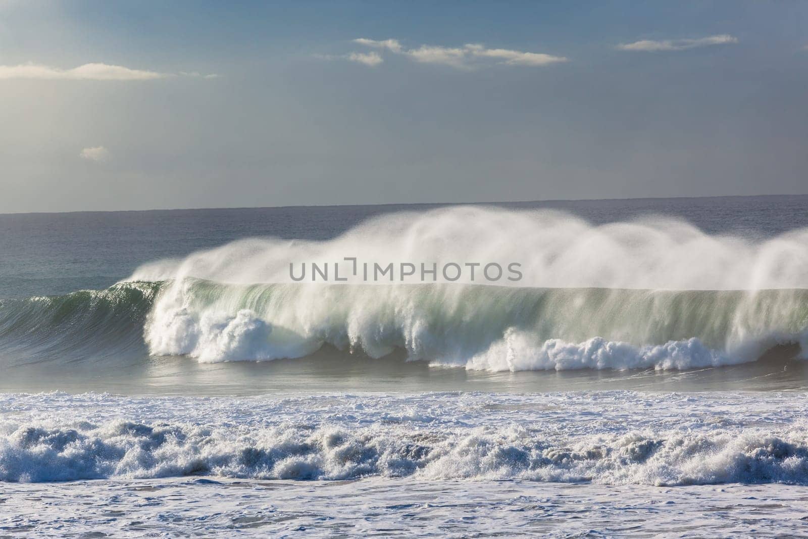 Ocean Waves crashing water power along beach rocky coastline from storm weather.