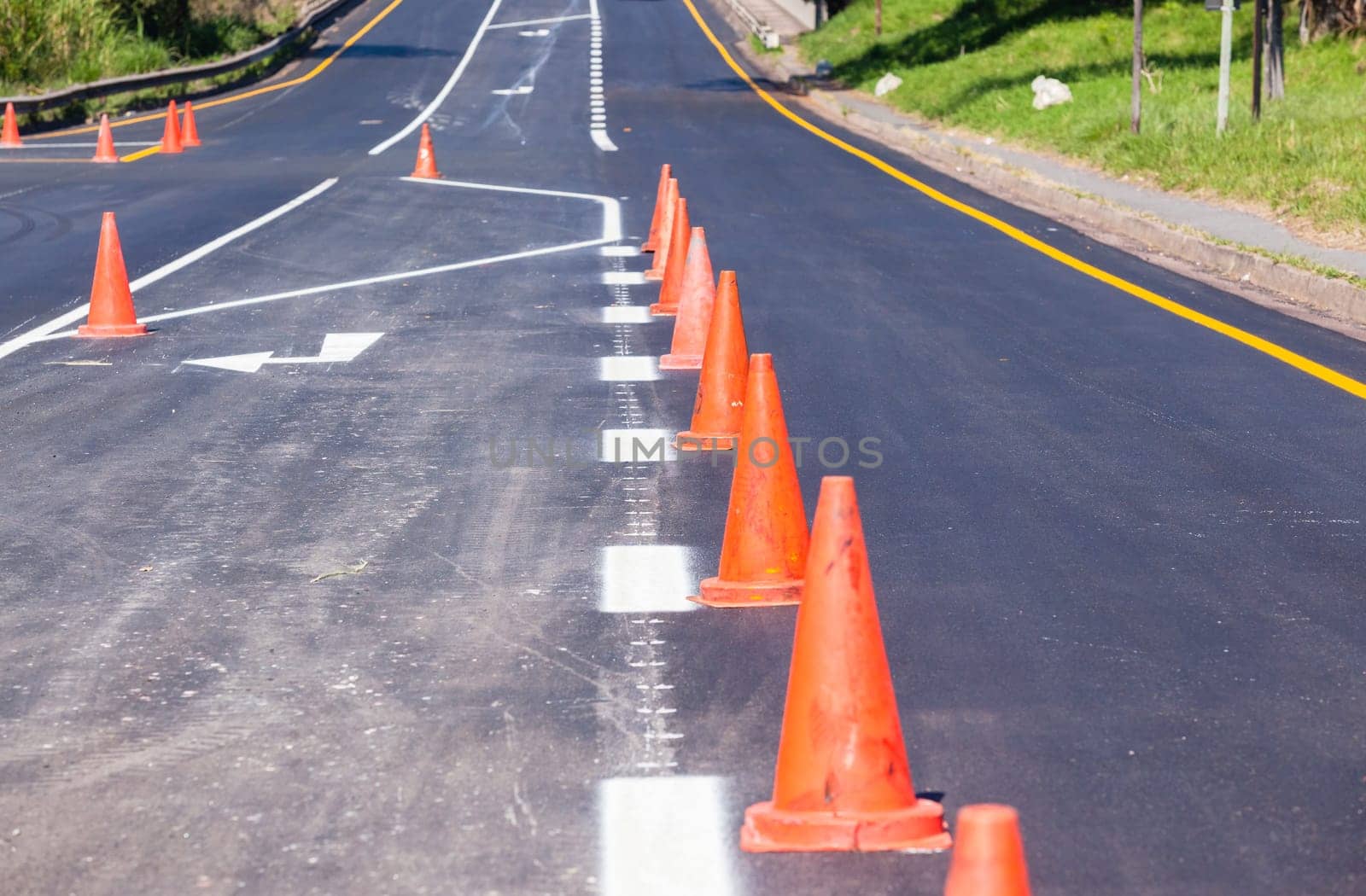Road painting lines on new on asphalt surface with orange markers safety for vehicle traffic.