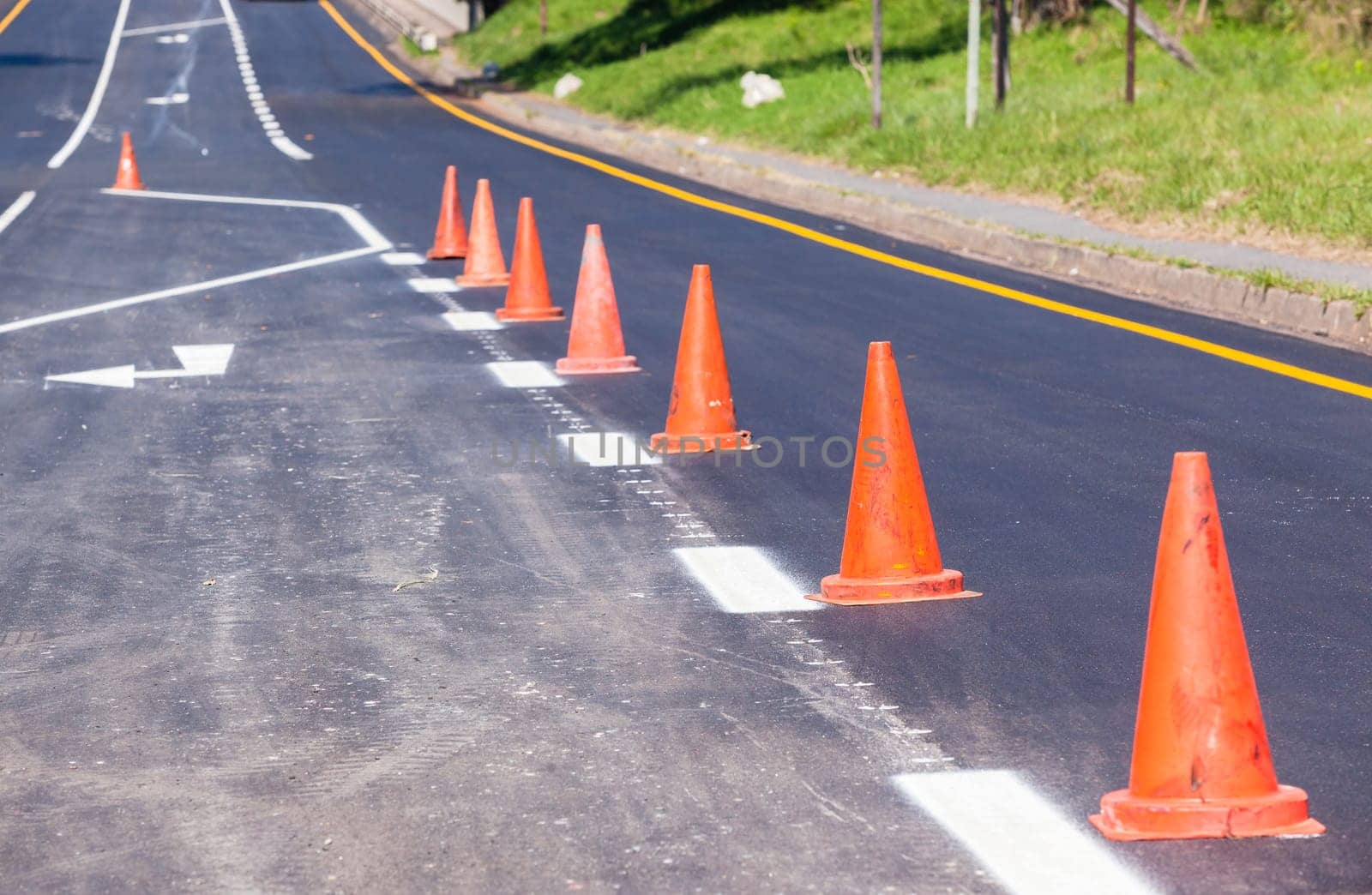 Road painting lines on new on asphalt surface with orange markers safety for vehicle traffic.