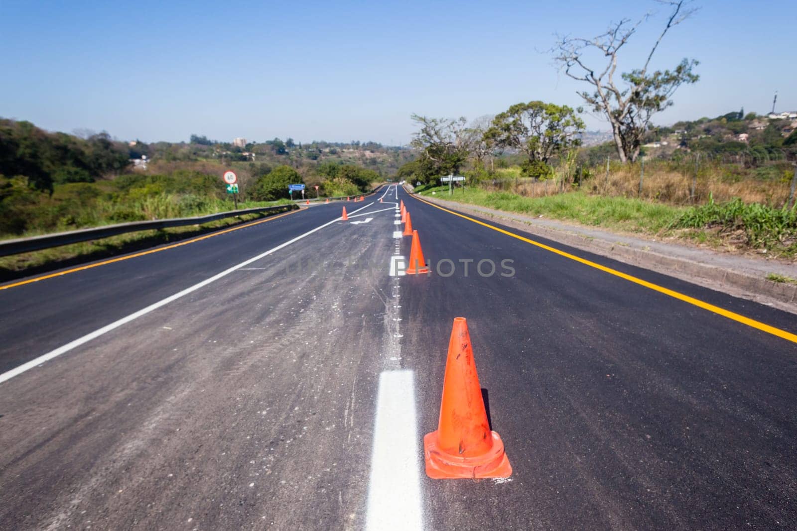 Road painting lines on new on asphalt surface with orange markers safety for vehicle traffic.