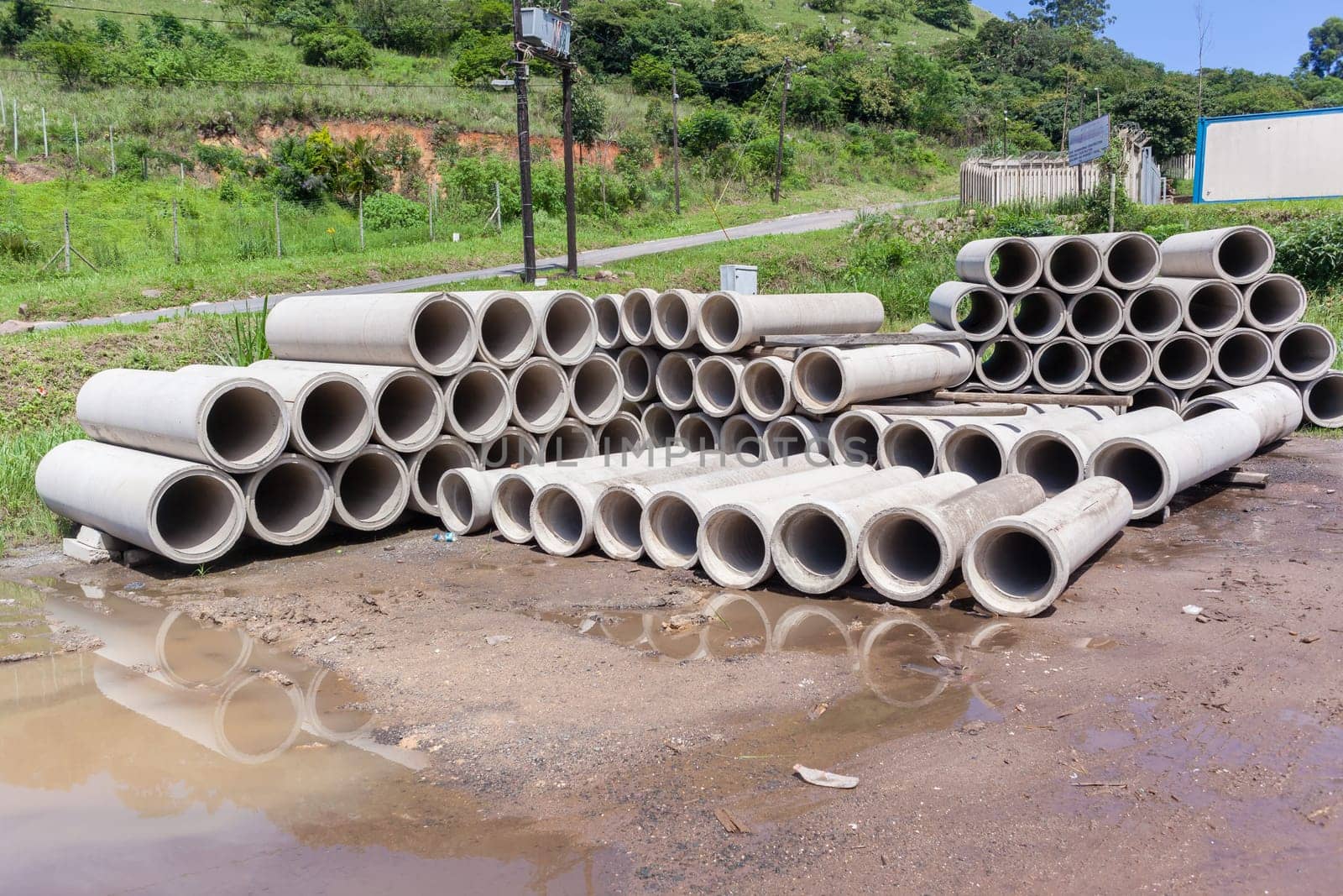 New manufactured concrete pipes stacked factory products for infrastructure industrial construction.