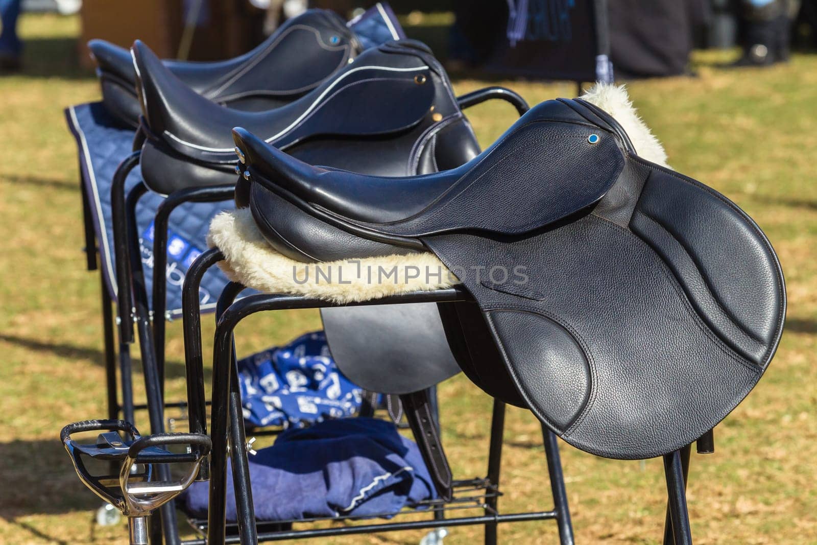Saddles new equestrian product equipment outdoors display  for rider clients riding horses.