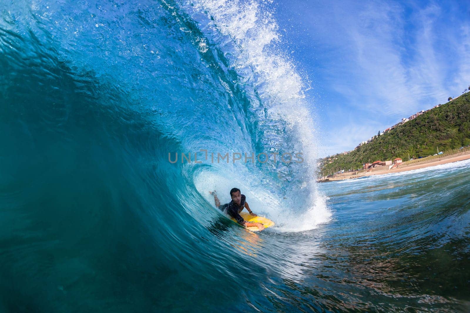 Surfing surfer body-boarder rides inside hollow ocean wave water action photo.