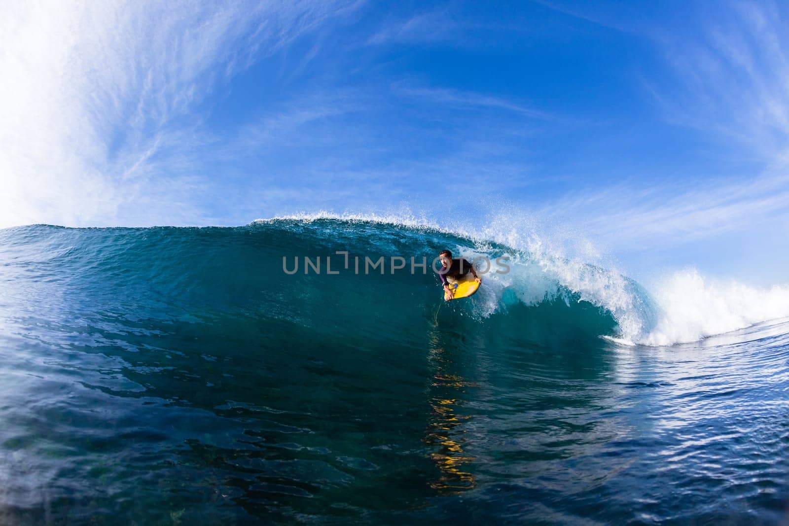 Surfing surfer body-boarder rides inside hollow ocean wave water action photo.