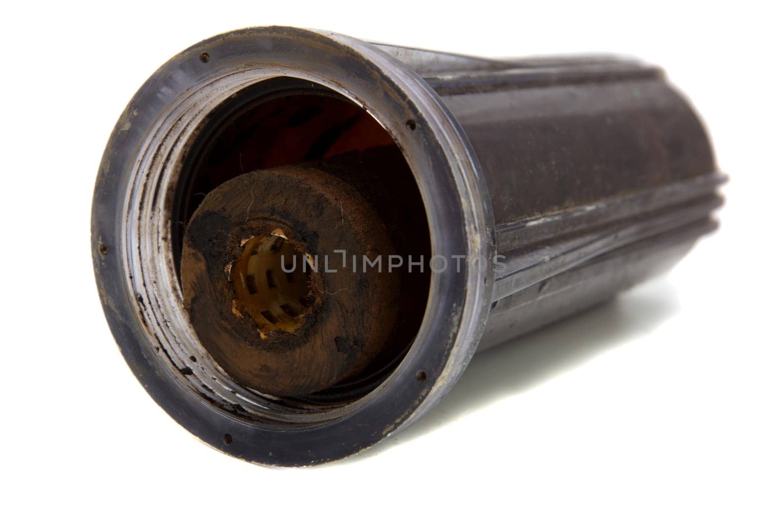 Old dirty water filter in plastic holder isolated on white background