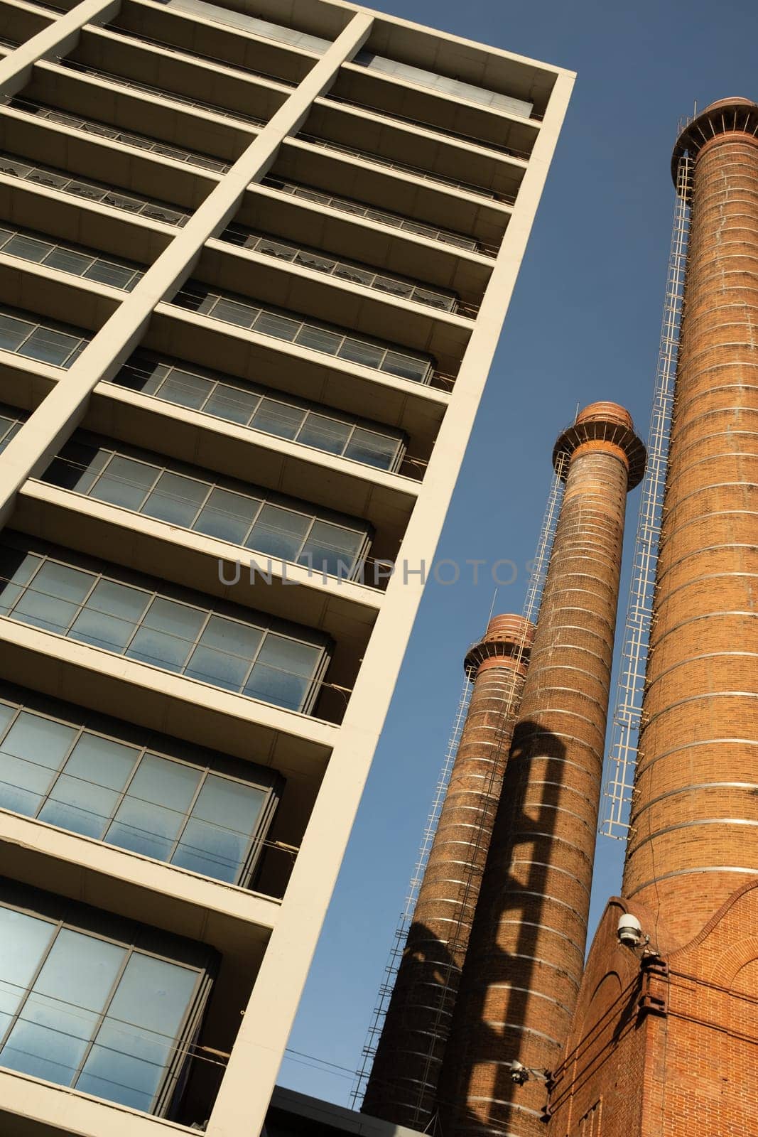 View from below of three red brick chimneys forming part of an old industrial complex in the popular district of Poble Sec, Barcelona, Catalonia, Spain