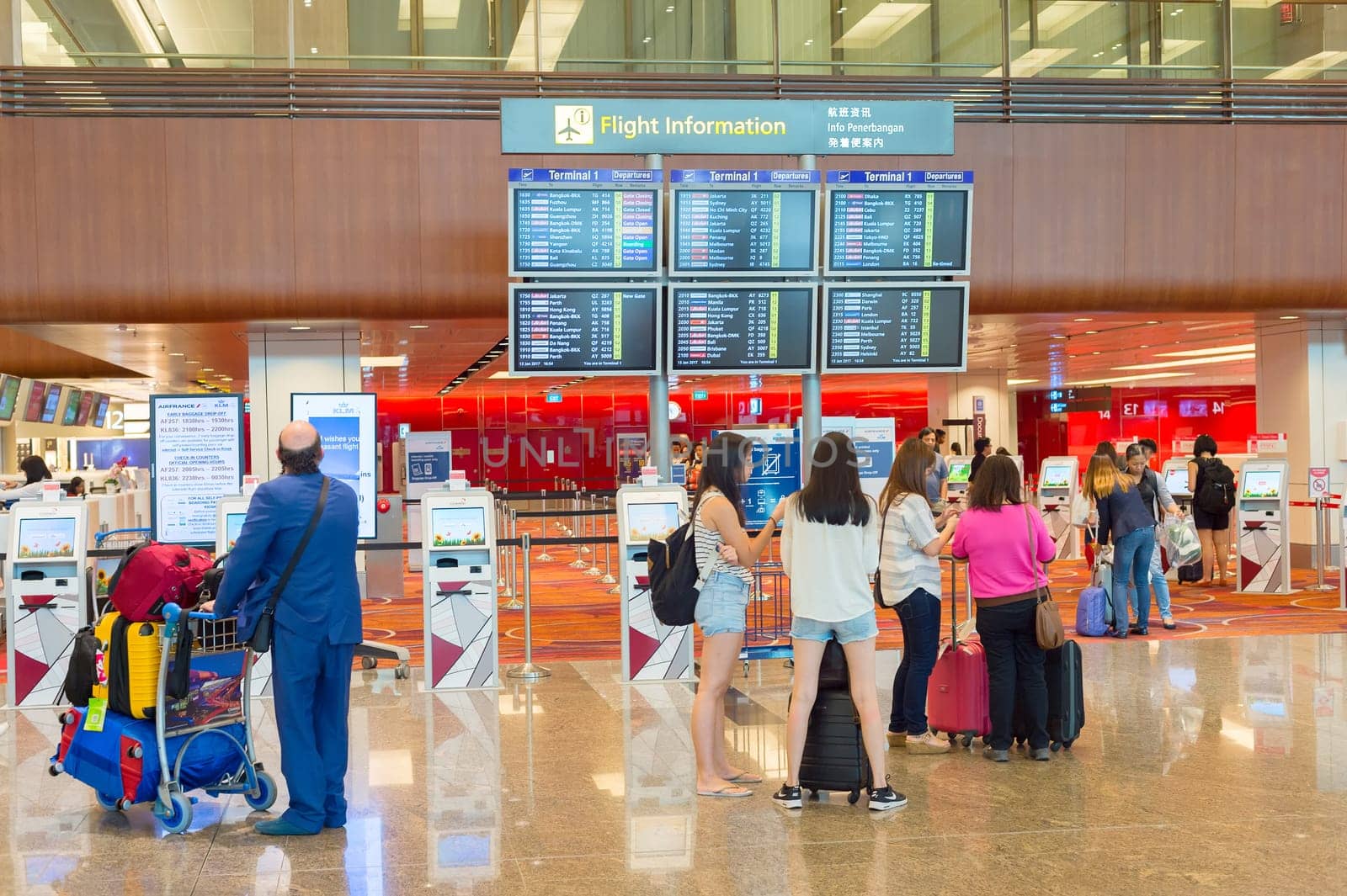 SINGAPORE - JANUARY 13, 2017: People looking at Flight information desk at Changi International airport in Singapore