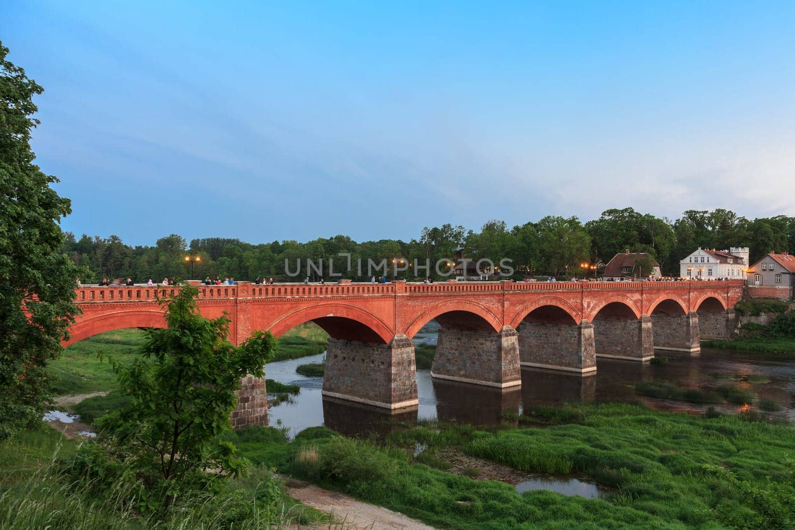 The old brick bridge over the Venta River in the evening. Kuldiga Latvia..