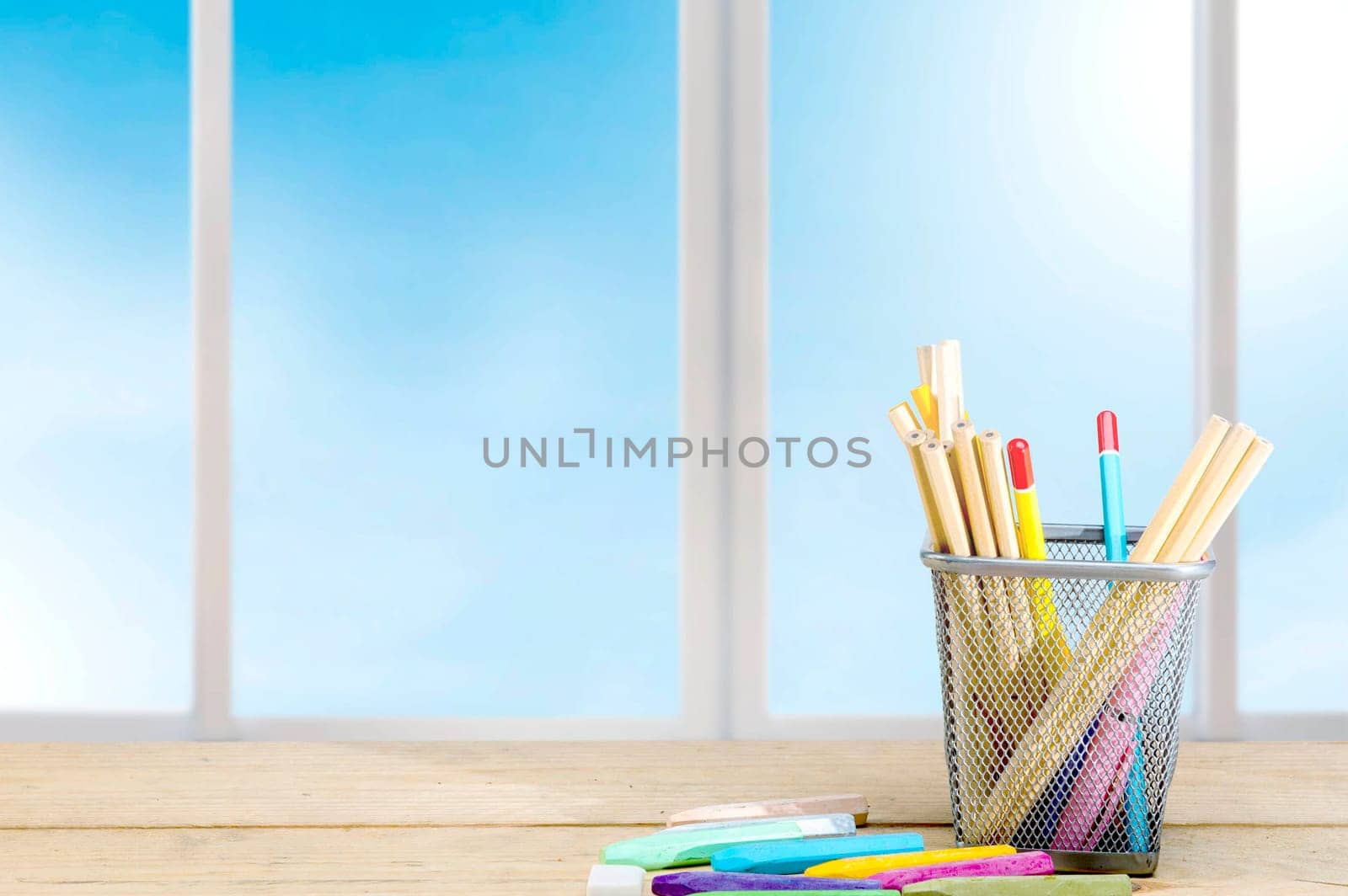 Pencils in basket container and colorful crayons on the wooden table. Back to School concept